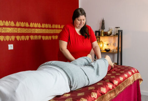 Person liegt auf Liege Julia steht daneben