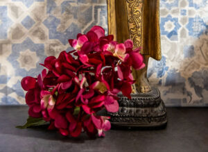 Magnolia, Meditation & Achtsamkeit, Julia Mauroschek - rote Bluemen zu Füßen einer asiatischen Statue