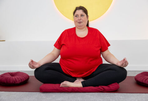 Magnolia, Meditation & Achtsamkeit, Julia Mauroschek sitzt in Meditationshaltung auf einer Yogamatte