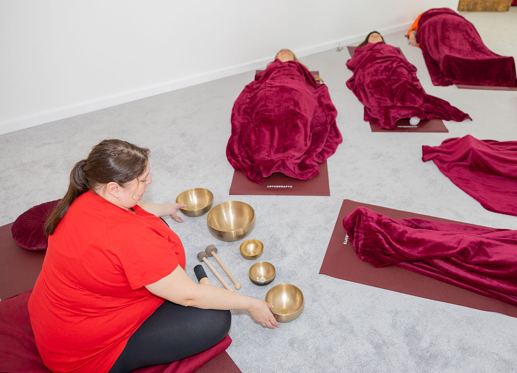 Magnolia, Meditation & Achtsamkeit, Julia Mauroschek Raum mit Personen auf Boden und Julia mit Klangschalen